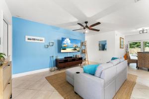 un salon avec un canapé et un mur bleu dans l'établissement Jupiter Coastal Cottage, à Jupiter