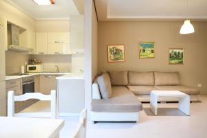 a living room with a couch and a kitchen at Casa Miel en el Botánico in Tirana