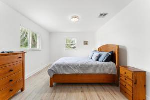 - une chambre avec un lit en bois et une commode dans l'établissement Jupiter Coastal Cottage, à Jupiter