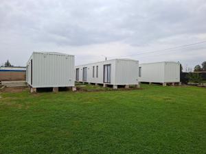 three white trailers sitting in a field of grass at Cabañas Celeste in Talca +3 photos