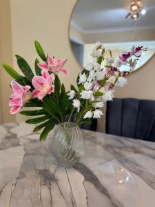 un vaso pieno di fiori rosa e bianchi su un tavolo di Apartment family friendly in Santo Domingo Este a San Isidro