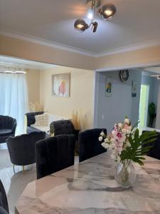 una sala da pranzo con tavolo e vaso di fiori di Apartment family friendly in Santo Domingo Este a San Isidro