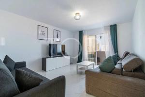 a living room with a couch and a television at Marina Palace duplex in Adeje