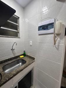 a bathroom with a sink and a phone on the wall at Apartment perto Praia e Metro, Melhor Localização in Rio de Janeiro