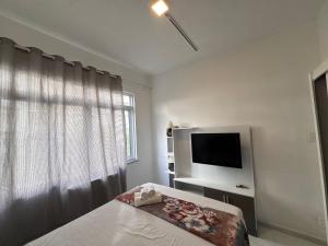 a bedroom with a bed and a flat screen tv at Apartment perto Praia e Metro, Melhor Localização in Rio de Janeiro +55 photos