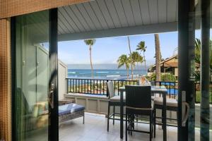 a balcony with a table and chairs and the ocean at Kahana Village 9 · KHV 9 2BR Oceanfront Condo w Panoramic Maui in Kahana