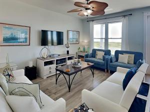a living room with two couches and a tv at So Serene in Galveston