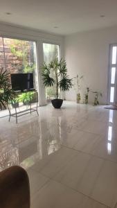 a living room with a large tile floor with plants at house cop30 in Ananindeua