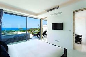 a living room with a tv and a large window at View Phuket Private Pool in Ban Karon