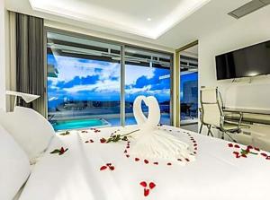 a white bed with a white swan decoration on it at View Phuket Private Pool in Ban Karon +48 photos