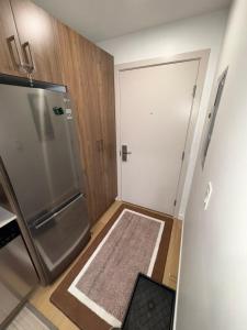 uma pequena cozinha com um frigorífico e uma porta em Studio Downtown , Rodgers Views, AC, Heated Free Underground Parking em Edmonton