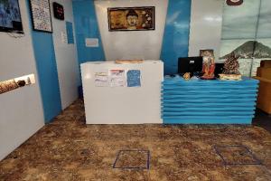 a white refrigerator in a room with a blue wall at Collection O Sri Subhamastu Grand in Vijayawada