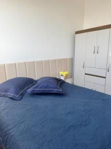 a bedroom with a blue bed with two blue pillows at Reserva Almagre Apto 403 in Cabedelo