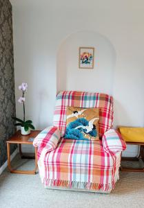 a plaid chair with a pillow on it in a living room at Catbells Sunrise Cottage Borrowdale Lake District in Keswick +35 photos