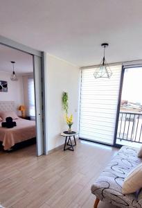 a bedroom with a bed and a couch and a window at Sensacional Departamento Centro - Mar 1D 1B in Antofagasta