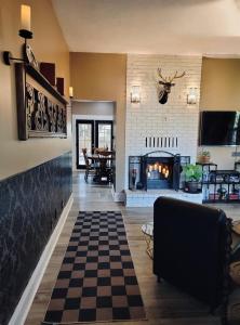 a living room with a fireplace and a checkered floor at Stag & Sparrow in Salem