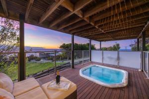 an outdoor deck with a hot tub on a patio at Martha's Maison Heated Spa & Unbeatable Bay Views in Safety Beach