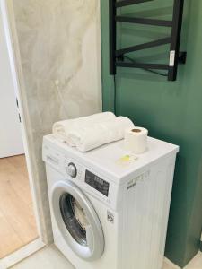 una lavadora en una habitación con una pared verde en Современные, светлые и уютные апартаменты в центре Астаны, en Astana