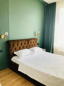 1 dormitorio con 1 cama grande con sábanas blancas y 2 lámparas en Современные, светлые и уютные апартаменты в центре Астаны, en Astana 1 foto más