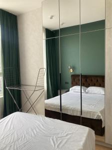 1 dormitorio con 2 camas y pared de cristal en Современные, светлые и уютные апартаменты в центре Астаны, en Astana