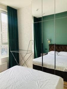 1 dormitorio con 2 camas y pared de cristal en Современные, светлые и уютные апартаменты в центре Астаны, en Astana