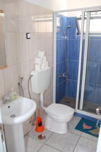 a bathroom with a toilet and a sink and a shower at T3 Mindelo in Mindelo