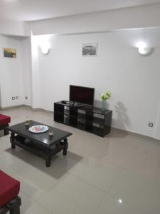 a living room with a coffee table and a tv at T3 Mindelo in Mindelo