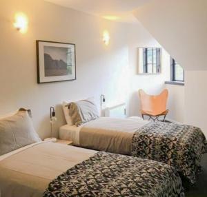 Un dormitorio con dos camas y una silla dentro. en House of Ullr, en Thredbo