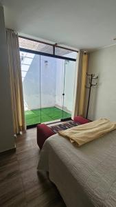 a bedroom with a large window with a large bed at Casita en Ica Villa Periodista cerca a Huacachina in Ica