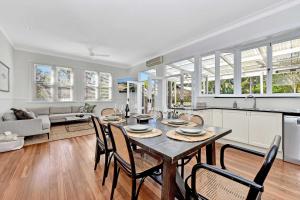 a kitchen and dining room with a table and chairs at Tosca Elegant Merewether Beach House with Pool in Merewether