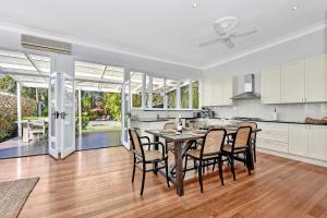 a kitchen and dining room with a table and chairs at Tosca Elegant Merewether Beach House with Pool in Merewether