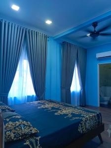 にあるIrfan Homestay Johor Lamaの青いベッドルーム(ベッド1台、天井ファン付)