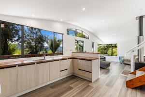 a kitchen with large windows and a living room at Rainforest Retreat 2Bdr in Auckland