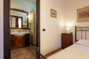 a bathroom with a bed and a sink and a mirror at Casa Vacanze Ponte del Duomo in Viterbo