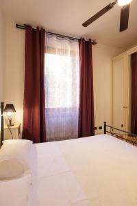 Un dormitorio con una cama blanca y una ventana. en Ponte del duomo, en Viterbo