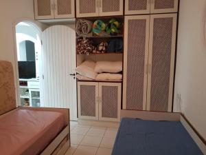 a room with a closet with a bed and towels at Casa de praia em Peruibe com muito verde! in Peruíbe