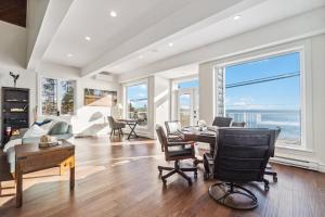 a living room with a table and chairs and windows at Vista Del Mar 596 in Hubbards