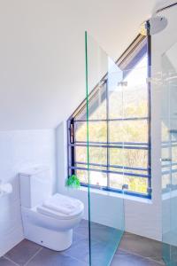 Un baño con inodoro y ventana. en House of Ullr, en Thredbo