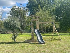 un parco giochi in legno con scivolo di Gîte calme près de La Flèche, idéal pour familles - FR-1-410-479 a Mansigné