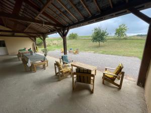 un gruppo di sedie e un tavolo in un patio di Gîte calme près de La Flèche, idéal pour familles - FR-1-410-479 a Mansigné