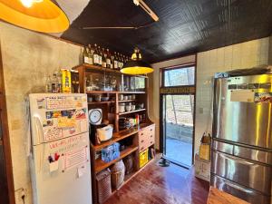 cocina con nevera y estante con botellas en Hotel Hibiscus, en Isla Miyako