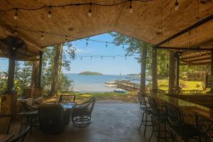 een bar met stoelen en uitzicht op het water bij Lakefront Luxury: Dock Fire Pit Game Room More in Lake Murray Shores