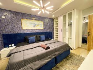 a bedroom with a large bed with a blue wall at IBIZA LAGoS in Lagos +33 photos
