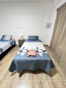 a bedroom with a bed with a blue blanket at Alvarez Apart in Ushuaia +2 photos