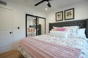 a bedroom with a bed with a pink comforter and pillows at Destination #50 in Placentia +56 photos