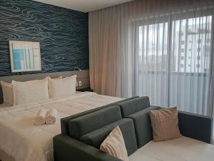 サンパウロにあるHotel RDS Oscar Freireの大きなベッドとソファのある寝室