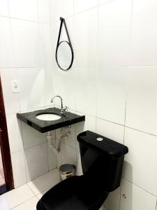 a bathroom with a black toilet and a sink at Temporada AK Freitas in Parnaíba