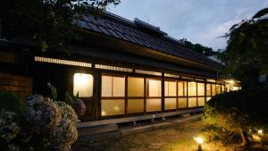 ein Gebäude mit Lichtern an der Seite in der Unterkunft Gateway to Hakuba & Snow Monkey - Historic 200yo Home in Nagano