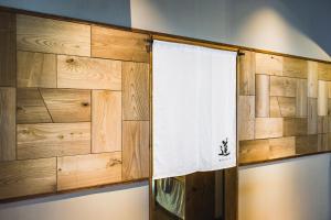 eine Holzwand mit einem weißen Handtuch auf einem Regal in der Unterkunft Gateway to Hakuba & Snow Monkey - Historic 200yo Home in Nagano + 54 Fotos