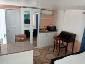 a room with a kitchen and a table and a piano at Thegreenhouse in Santiago de los Caballeros